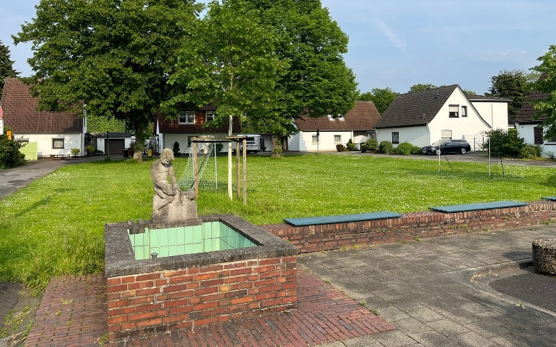 Die Nordparksiedlung mit dem Brunnen und einer Wiese